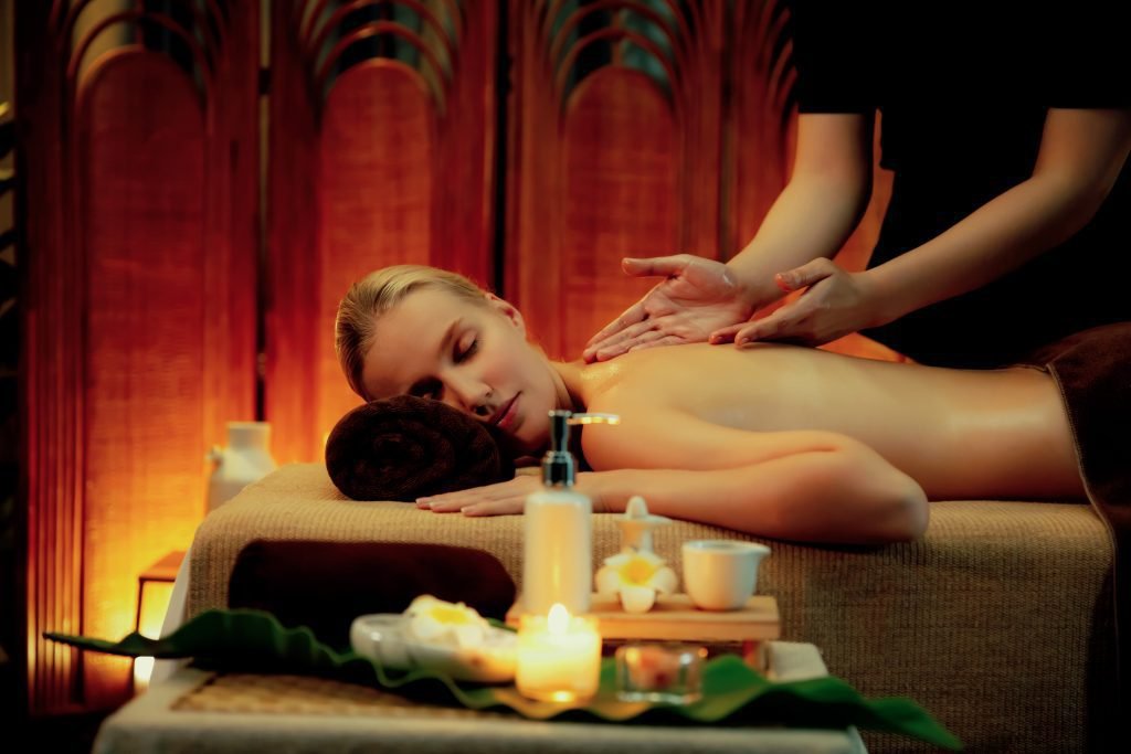 Woman receiving a relaxing back massage surrounded by candles and spa oils at The Bali Spa, a spa in Hyderabad