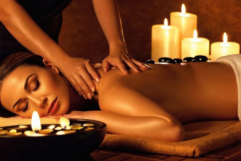 Beautiful woman receiving back hot stones massage in beauty spa salon. Beauty treatment concept
