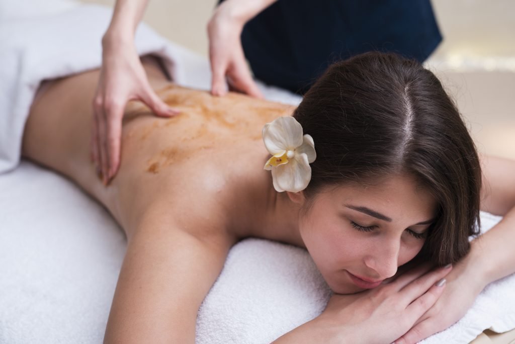 Therapist applying a tropical body treatment to a woman's back at The Bali Spa, a spa in Hyderabad