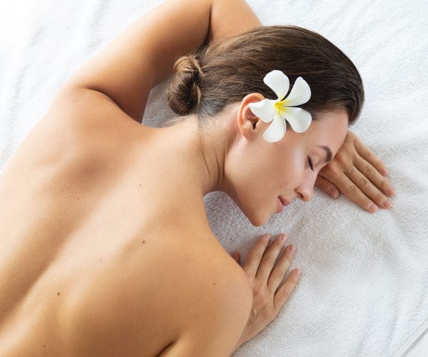 Young and beautiful woman is lying and relaxing after massage session