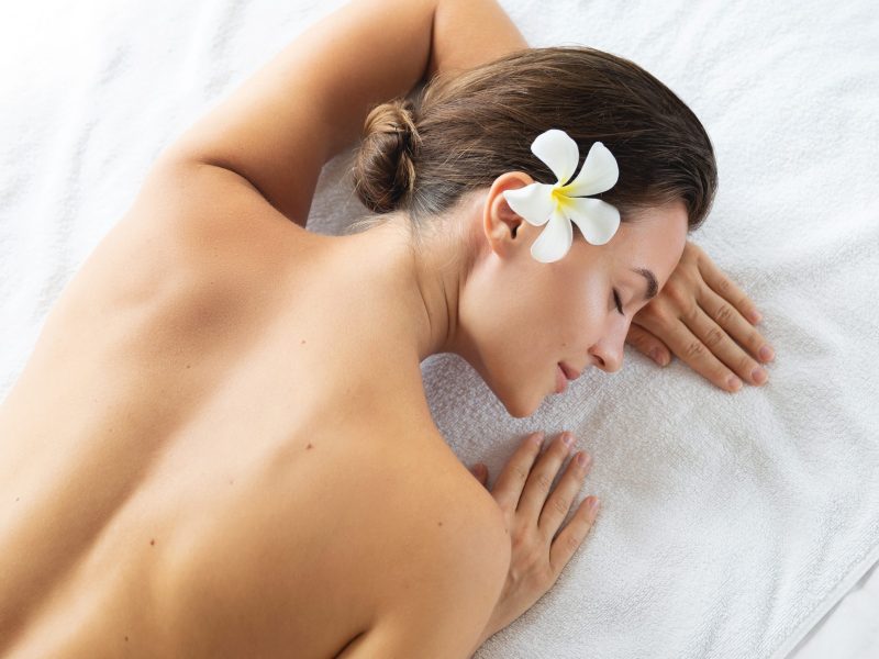 Woman is lying and relaxing after massage session Young and beautiful woman is lying and relaxing after massage session